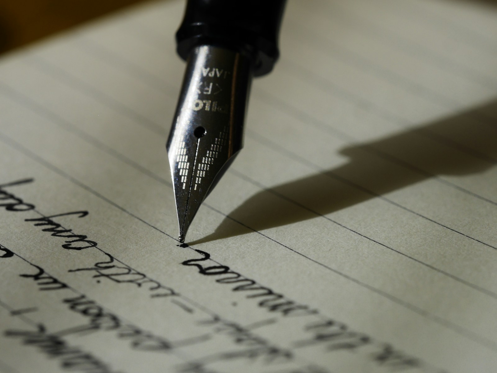 A notebook, pen, and warm workspace for thoughtful creative work