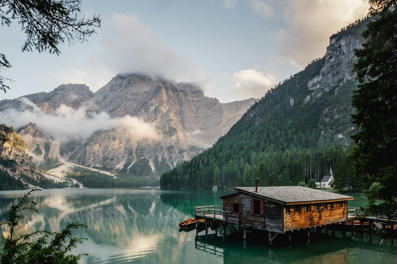Quiet green hillside and reflective lake surrounded by mountains