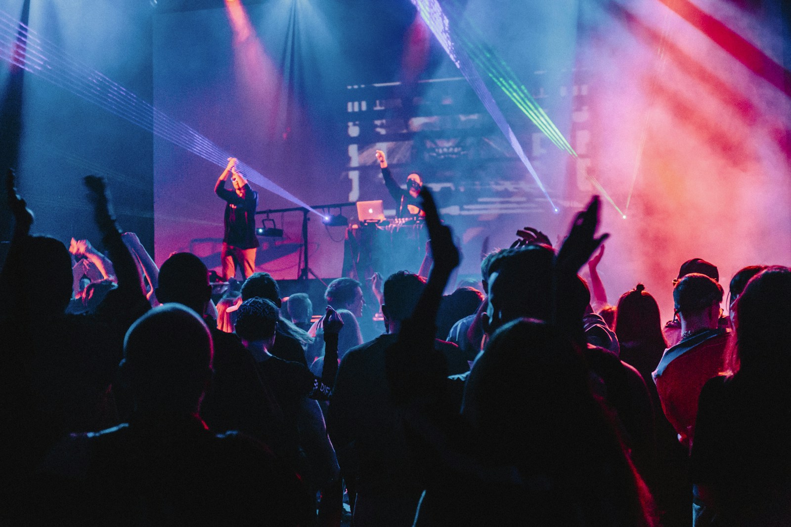 People enjoying a live concert performance beneath an industrial roof