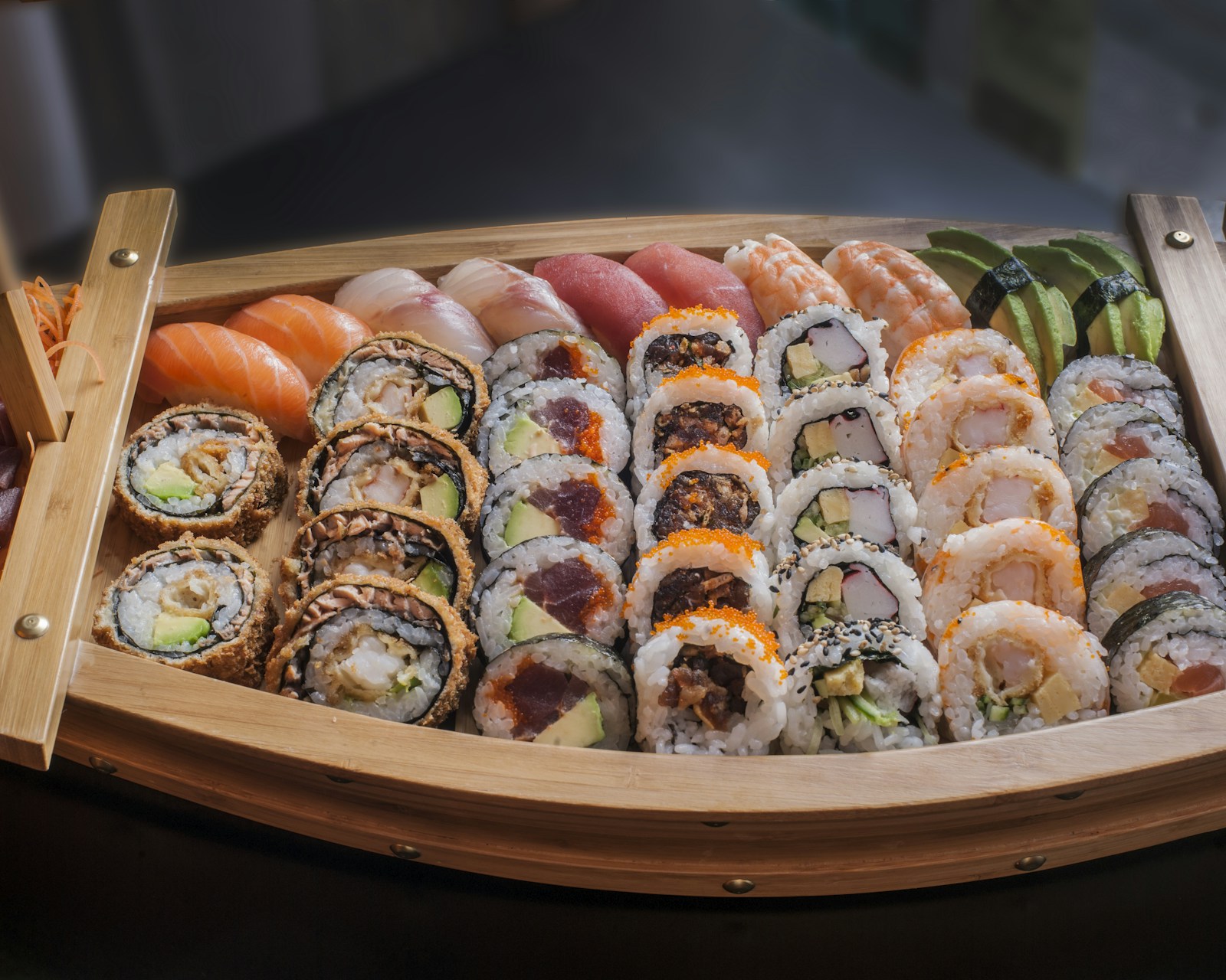 Fresh sushi and sashimi arranged on handmade ceramic serving dishes